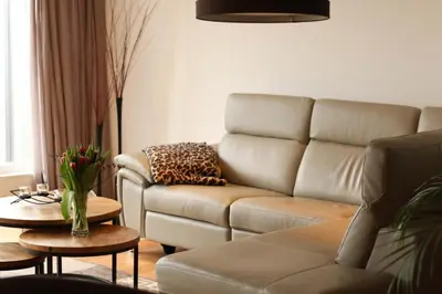 a living room with a couch and a table at Guesthouse BedNboot met terras aan het water in Rijpwetering