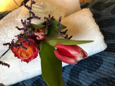 a bouquet of flowers sitting on a towel at Guesthouse BedNboot met terras aan het water in Rijpwetering