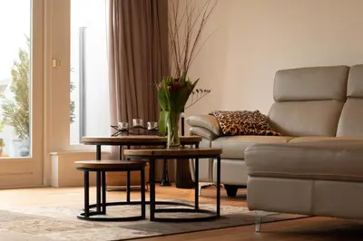a living room with a couch and a table at Guesthouse BedNboot met terras aan het water in Rijpwetering