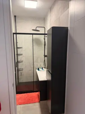 a bathroom with a glass shower with a sink at Scottish Thistle in Zandvoort