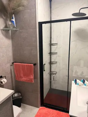 a bathroom with a shower with a glass door at Scottish Thistle in Zandvoort