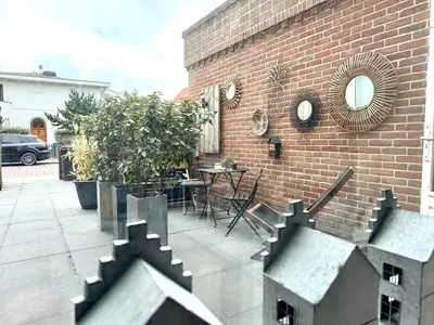 a patio with a table and a brick building at Shorestay Zandvoort Beachhouse in Zandvoort