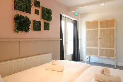 a bedroom with a white bed and a window at Vakantiehuis Tussen Duin en Strand by Droomvilla in Egmond aan den Hoef