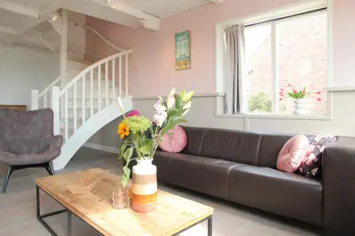 a living room with a couch and a table at Vakantiehuis Tussen Duin en Strand by Droomvilla in Egmond aan den Hoef