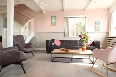 a living room with a couch and chairs and a table at Vakantiehuis Tussen Duin en Strand by Droomvilla in Egmond aan den Hoef