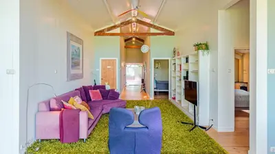 a living room with a purple couch and a green rug at Spa house in Bergen