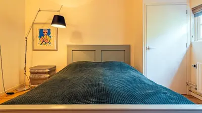 a bedroom with a bed with a black comforter at Spa house in Bergen