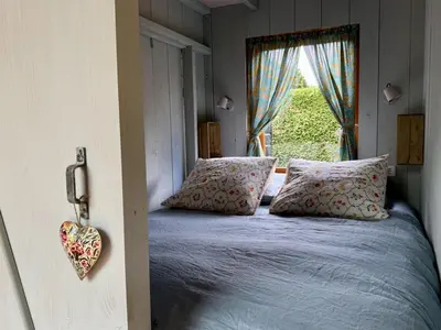 a bedroom with a bed with pillows and a window at In de Aap - Appartementen & Guesthouse in Bergen