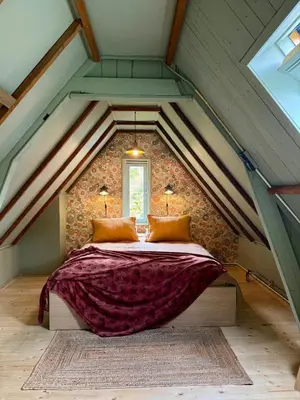 a bedroom with a large bed in a attic at In de Aap - Appartementen & Guesthouse in Bergen