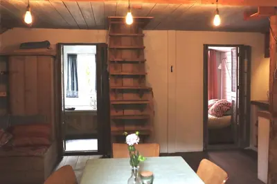 a living room with a table and a book shelf at In de Aap - Appartementen & Guesthouse in Bergen