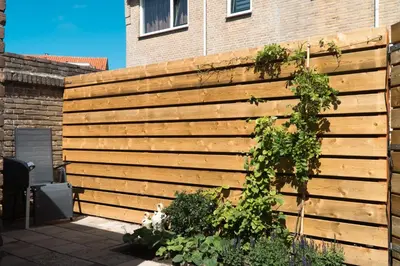 a wooden fence in front of a house at Zomerhuis aan Zee in Noordwijk aan Zee