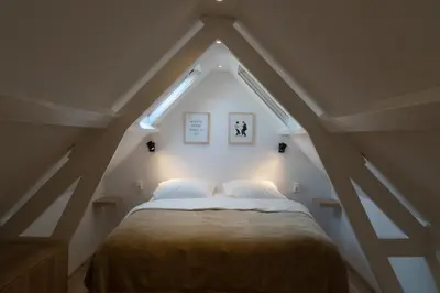a bedroom with a large bed in a attic at Zomerhuis aan Zee in Noordwijk aan Zee
