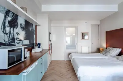 a bedroom with two beds and a tv on a counter at Studio Loren / Studio Fellini in Zandvoort