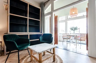 a living room with two green chairs and a table at Studio Loren / Studio Fellini in Zandvoort