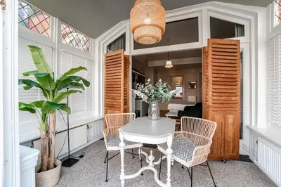 a dining room with a white table and chairs at Studio Loren / Studio Fellini in Zandvoort