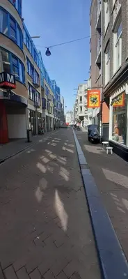 an empty street in a city with tall buildings at IRU, not for parties, not a hotel, room with no kitchen in Amsterdam