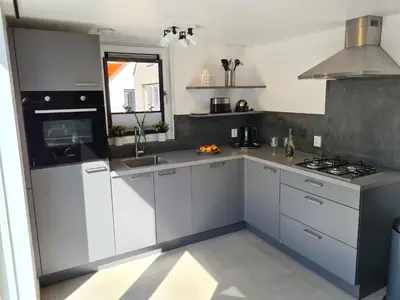 a kitchen with white cabinets and a sink and a stove at Bungalow 76 op Recreatiepark de Wielen in Sint Maarten