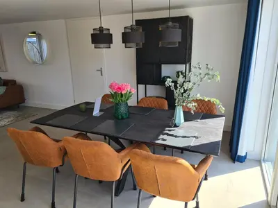 a dining room with a black table and chairs at Bungalow 76 op Recreatiepark de Wielen in Sint Maarten