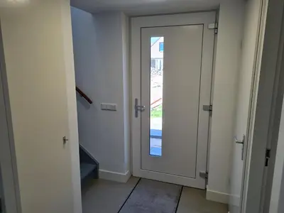 a hallway with a door with a glass window at Bungalow 76 op Recreatiepark de Wielen in Sint Maarten