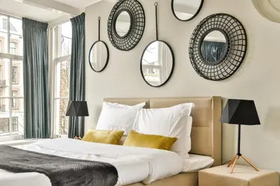 a bedroom with mirrors on the wall and a bed at Spiegelgracht Apartments with Canal View in Amsterdam