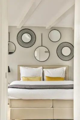 a bedroom with a bed with four mirrors on the wall at Spiegelgracht Apartments with Canal View in Amsterdam
