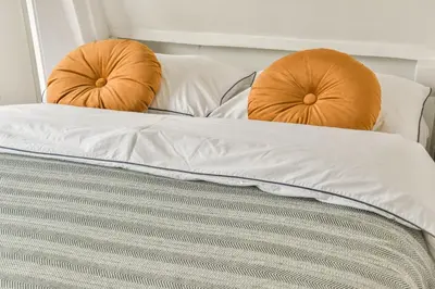 two orange pillows sitting on top of a bed at Spiegelgracht Apartments with Canal View in Amsterdam