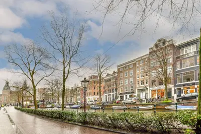 a city street with buildings and a canal with boats at Spiegelgracht Apartments with Canal View in Amsterdam