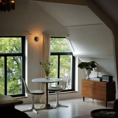 a living room with a table and chairs and windows at Boutique B&B in Edam in Edam