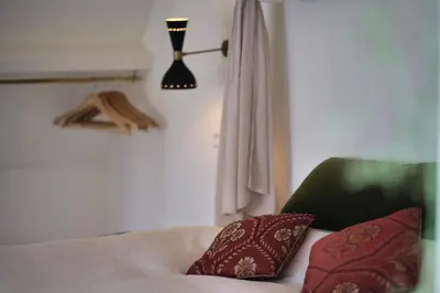 a bedroom with a bed with a green chair and two pillows at Boutique B&B in Edam in Edam