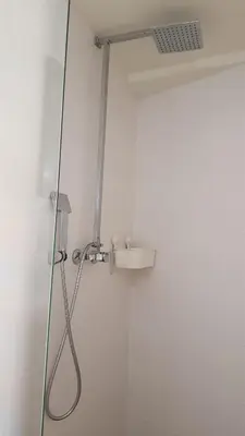a shower with a shower head and a sink at T-Rots, prachtig zomerhuis in Noordwijk aan Zee