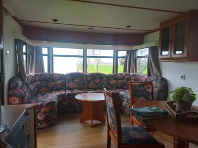 a living room with a couch and a table at De Boerenskuur..chalet.. in Assendelft