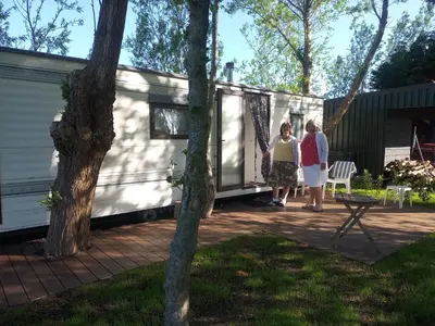 two women standing outside of a tiny house at De Boerenskuur..chalet.. in Assendelft