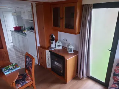 a kitchen with a table and a stove in a room at De Boerenskuur..chalet.. in Assendelft