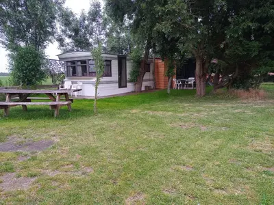 a campsite with a picnic table and a picnic table at De Boerenskuur..chalet.. in Assendelft