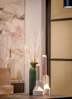 a green vase with two candles and flowers on a table at ApartHotel Boutique by Urban Home Stay in Alkmaar