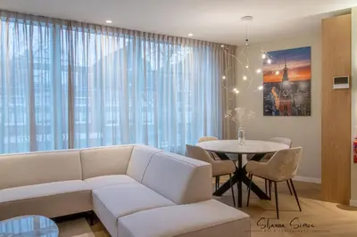 a living room with a white couch and a table at ApartHotel Boutique by Urban Home Stay in Alkmaar