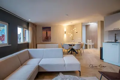 a living room with a white couch and a table at ApartHotel Boutique by Urban Home Stay in Alkmaar