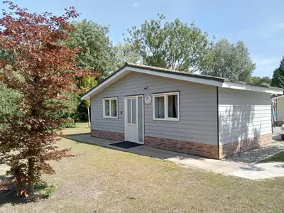 a small shed with a white door in a yard at Domstad Resort Utrecht Vakantiewoningen in Utrecht
