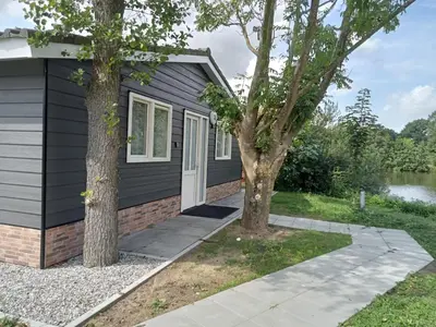 a home with a black house and two trees at Domstad Resort Utrecht Vakantiewoningen in Utrecht
