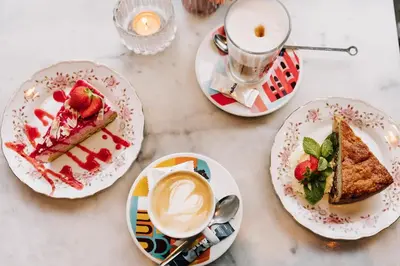 a table with plates of food and a cup of coffee at Boutique Hotel LE•BAR in Zandvoort