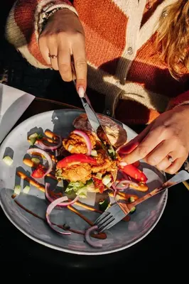 a person cutting a plate of food with a fork and knife at Boutique Hotel LE•BAR in Zandvoort
