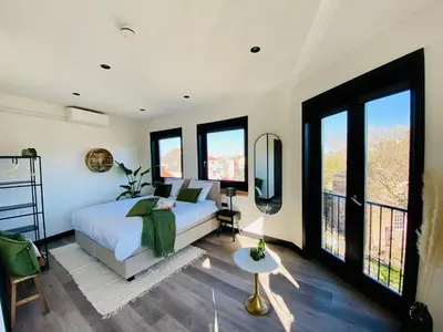 a bedroom with a bed and large windows at Boutique Hotel LE•BAR in Zandvoort