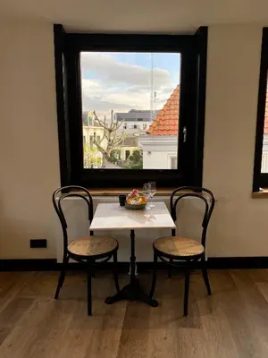 a table and two chairs in a room with a window at Boutique Hotel LE•BAR in Zandvoort