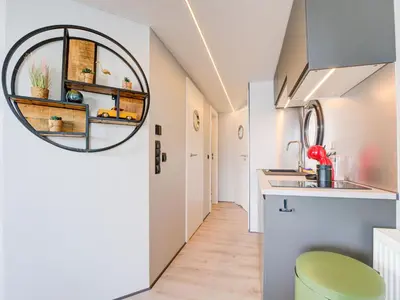 a kitchen with white cabinets and a green stool at Beautiful houseboat in Marina of Volendam in Volendam