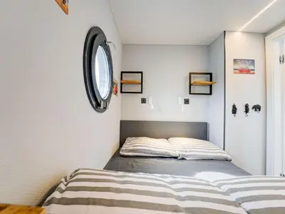 a bedroom with a bed and a round clock on the wall at Beautiful houseboat in Marina of Volendam in Volendam