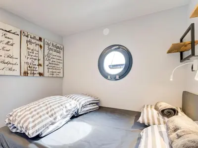a bedroom with a bed and a round mirror at Beautiful houseboat in Marina of Volendam in Volendam