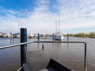 a boat is docked in a marina with boats at Beautiful houseboat in Marina of Volendam in Volendam