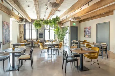 a restaurant with wooden ceilings and tables and chairs at Bistrotel 't Amsterdammertje in Nieuwersluis