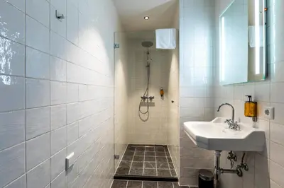 a bathroom with a shower and a sink at Bistrotel 't Amsterdammertje in Nieuwersluis