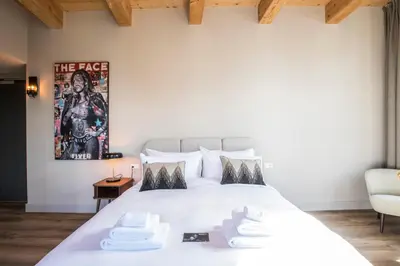 a bedroom with a white bed with a poster on the wall at Bistrotel 't Amsterdammertje in Nieuwersluis